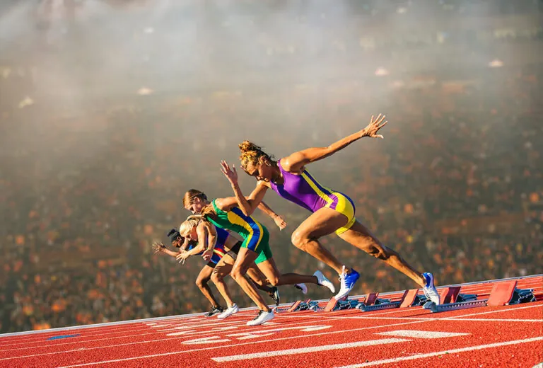 Vrouwelijke sprinters beginnen aan de race op het atletiekveld.