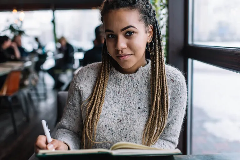 Vrouw schrijft in notitieblok in café