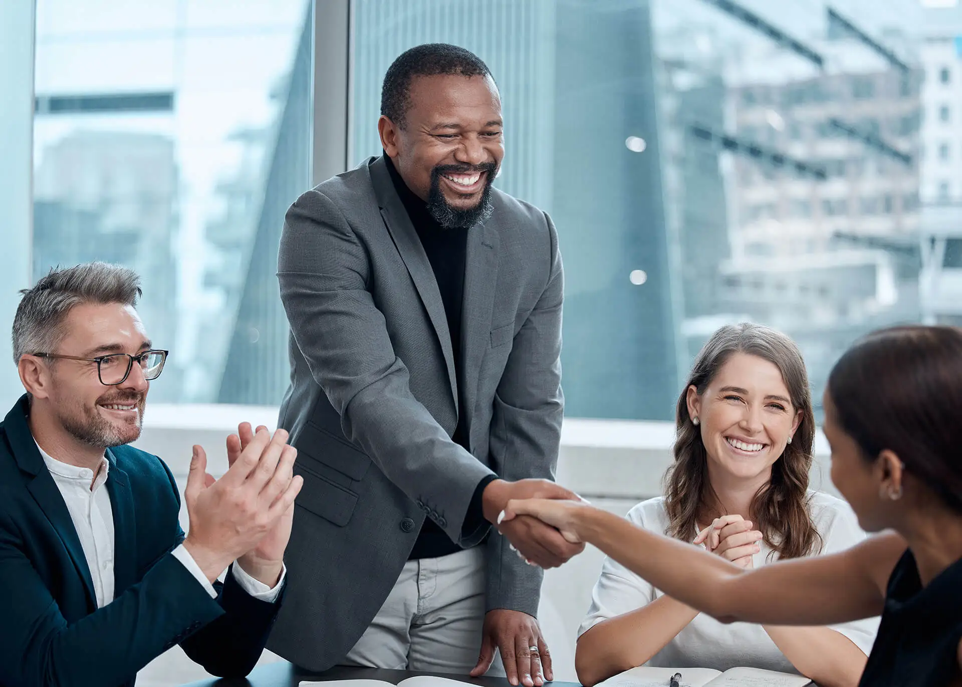 Business meeting handshake and clapping.